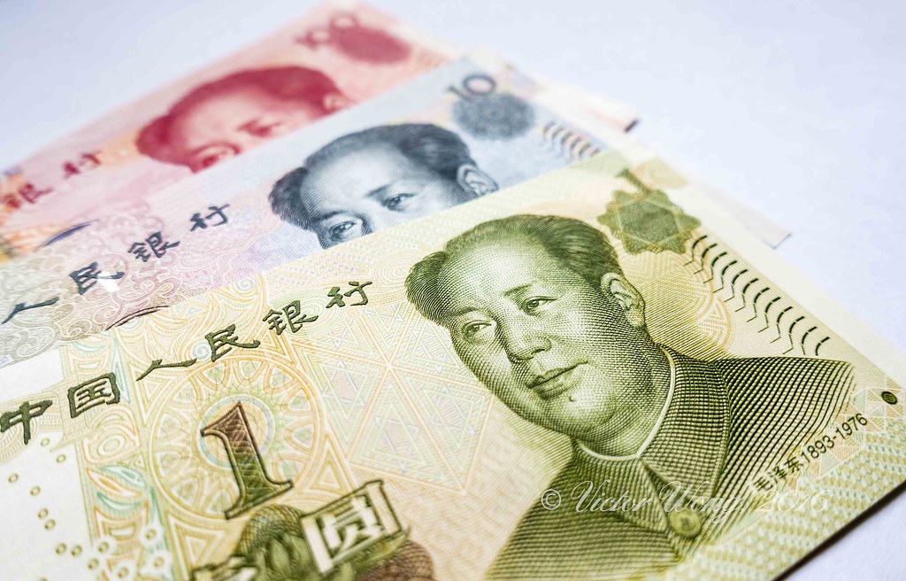 Billetes chinos de yuan con imagen de Mao Zedong sobre fondo blanco