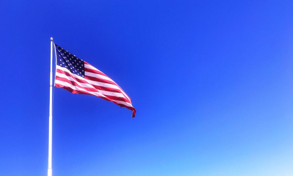 Bandera de Estados Unidos ondeando contra cielo azul despejado