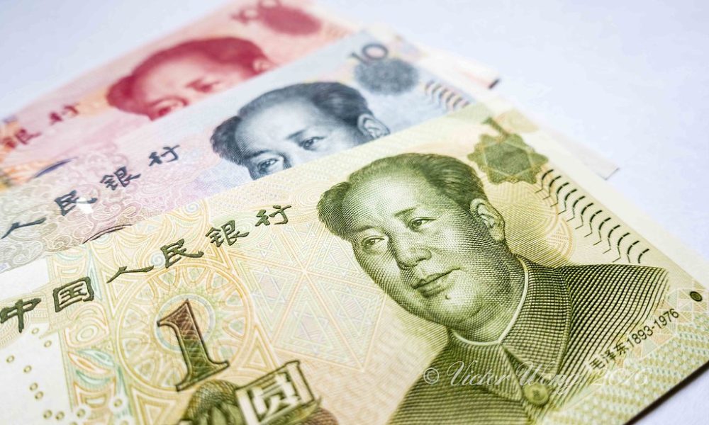 Billetes chinos de yuan con imagen de Mao Zedong sobre fondo blanco