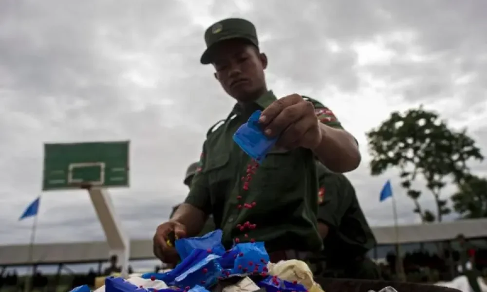 Member of United Wa State Army empty packets of yaba pills during a drugs burning ceremony. (AFP pic). Obtenida de https://www.freemalaysiatoday.com/category/world/2019/11/16/china-targets-asias-mega-rich-meth-syndicate
