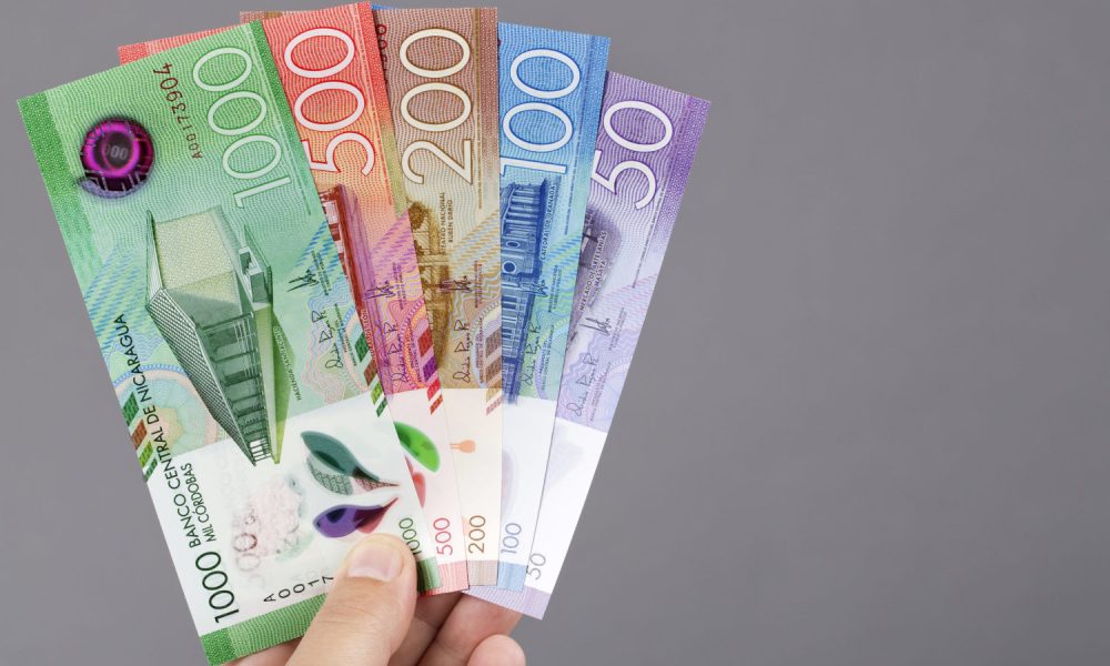 Billetes de crdobas nicaragenses de distintas denominaciones sostenidos en una mano