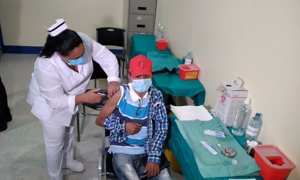 Enfermera administra vacuna COVID-19 a hombre con mascarilla